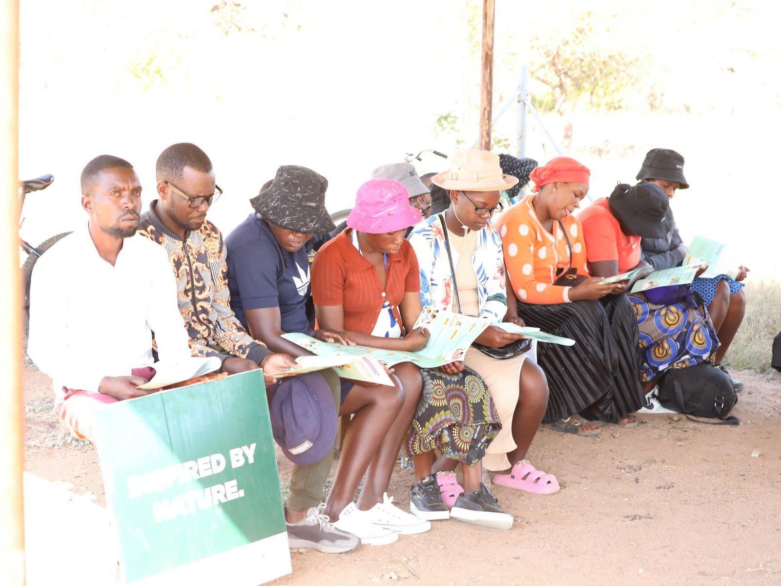 Community members reading programme materials, Zimbabwe